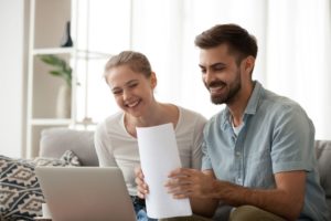 Young smiling couple looking at a laptop