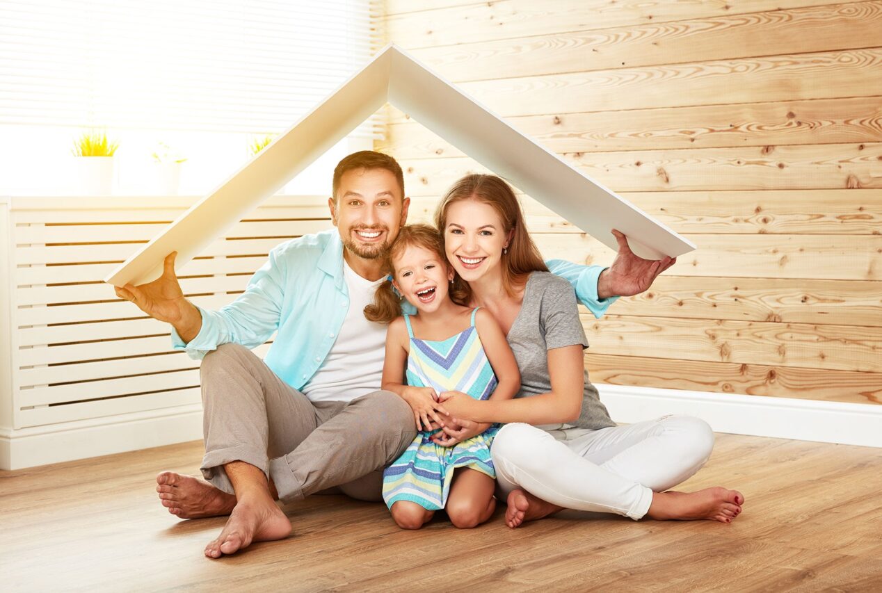 Family at home holding a wooden roof