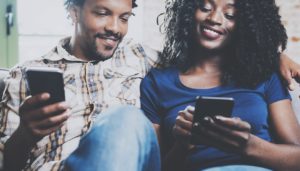 happy couple looking at phones