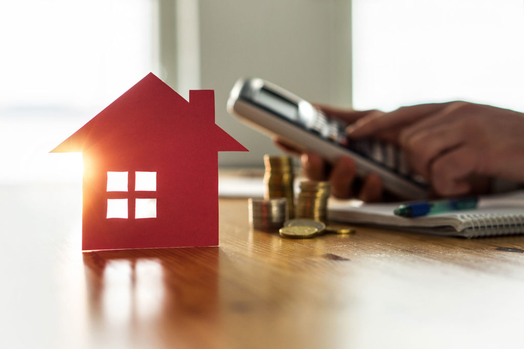 Man checking cost of house on calculator