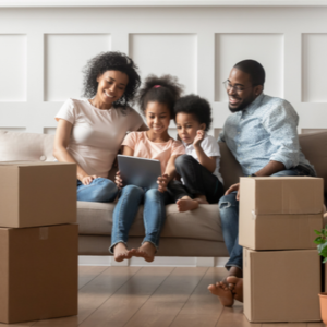 African American couple and kids on couch with boxes