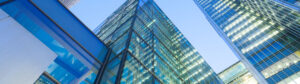 High rise glass building with lights on and blue sky