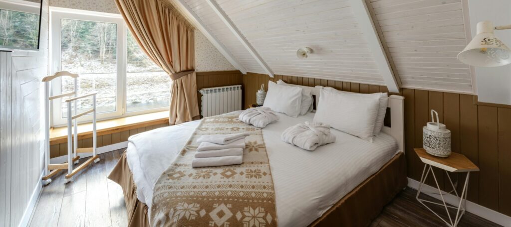 Converted attic with curtains and bed and timber floor