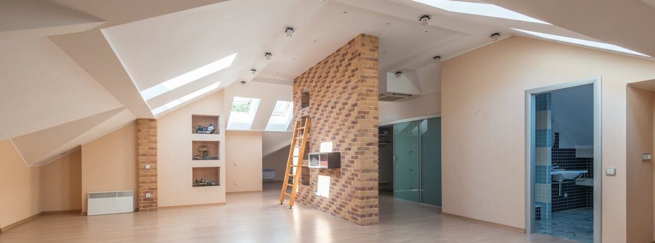 attic with ladder and brick wall