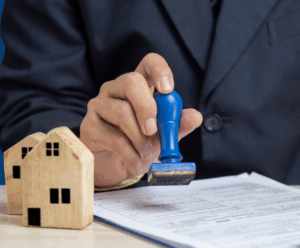 Man stamping form with wooden house